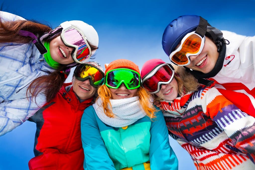 Five happy friends wearing goggles