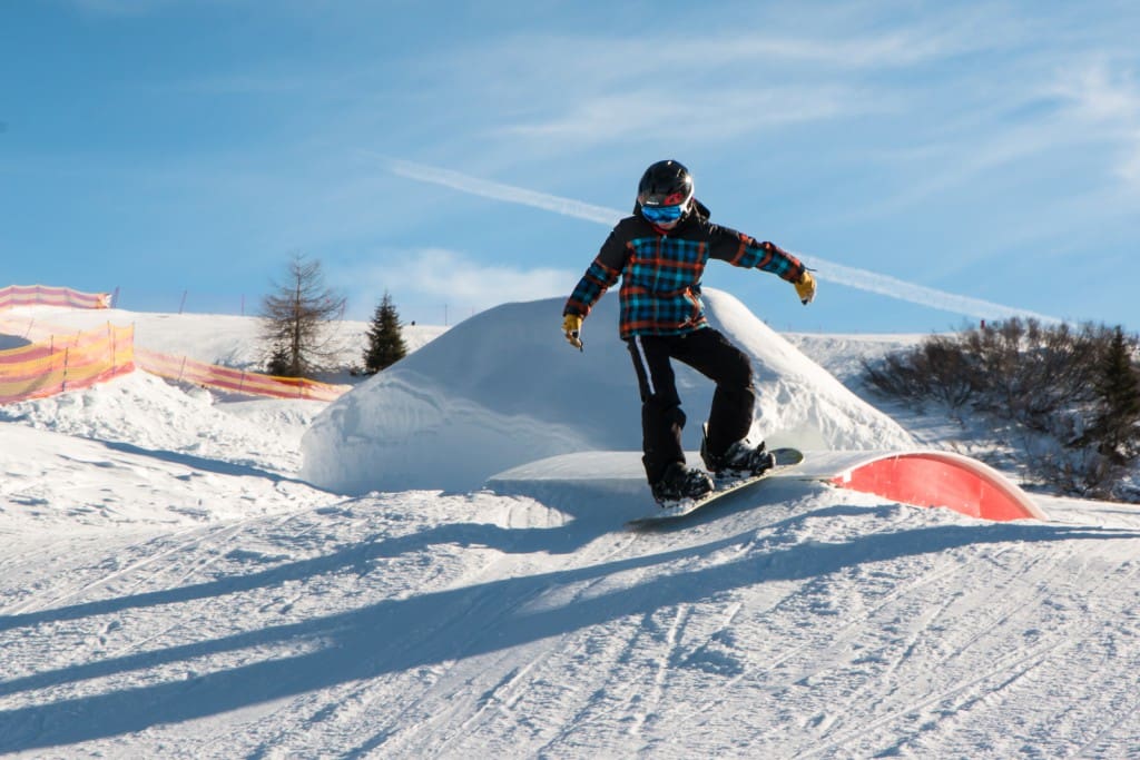 Freestyle Snowboarder With Helmet In Snowpark