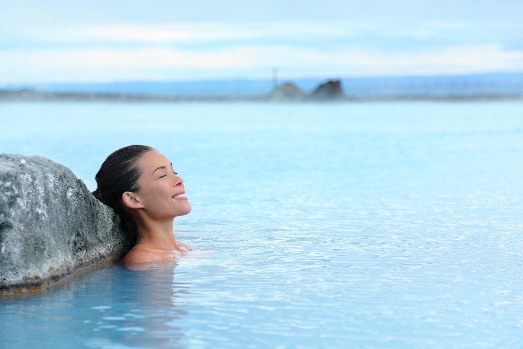 Geothermal spa. Woman relaxing in hot spring pool on Iceland. Gi