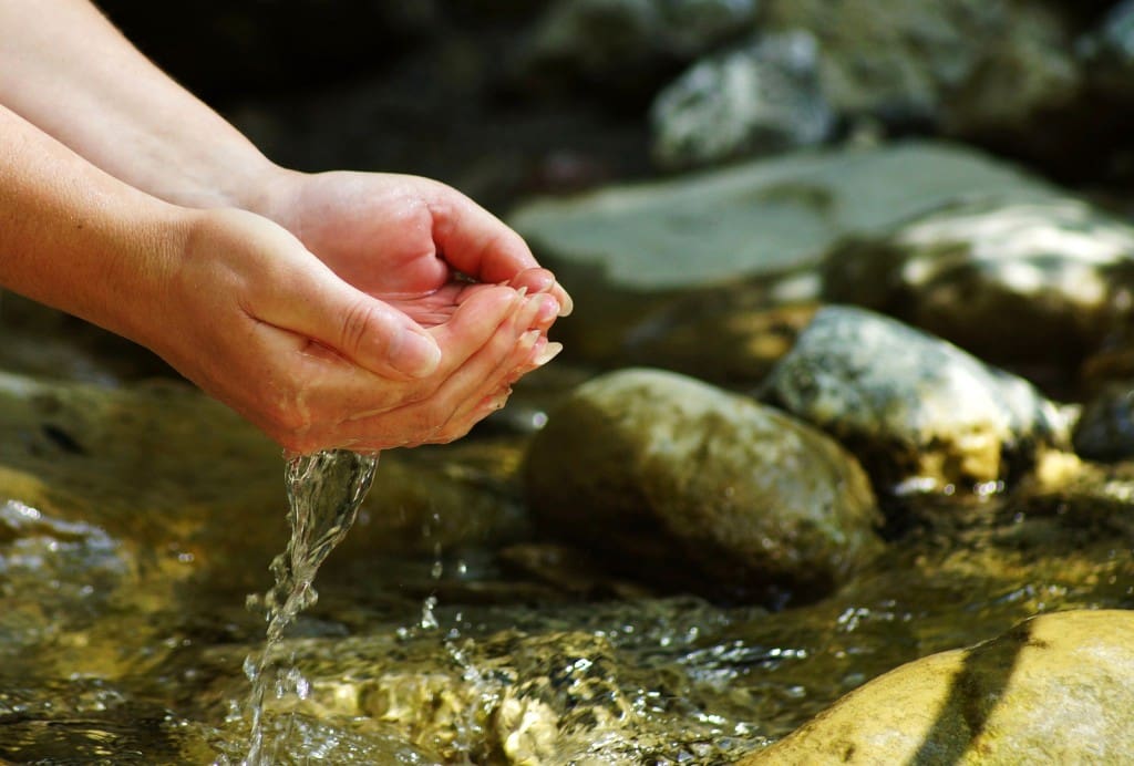 Woman hands on a stream in the Alps