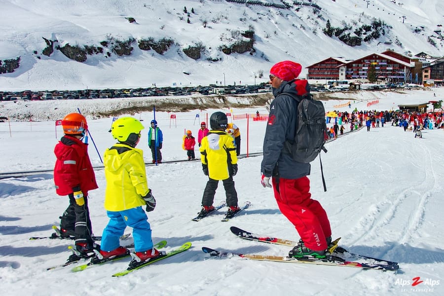 Kids skiing on the slopes with the Alpine mountains in the background