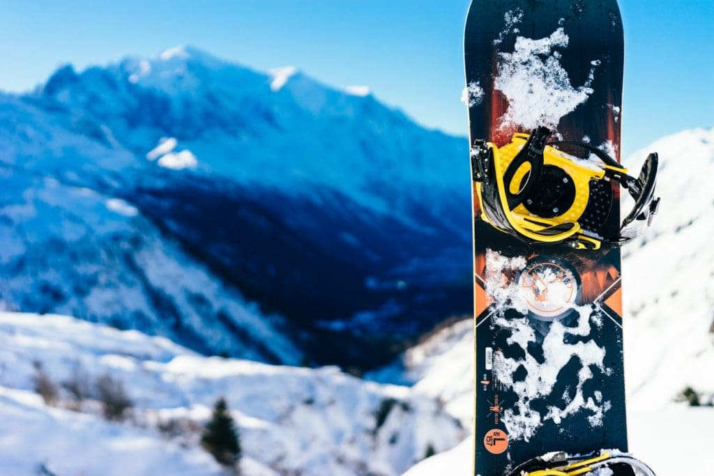 A snowboard with snowy mountains in the background