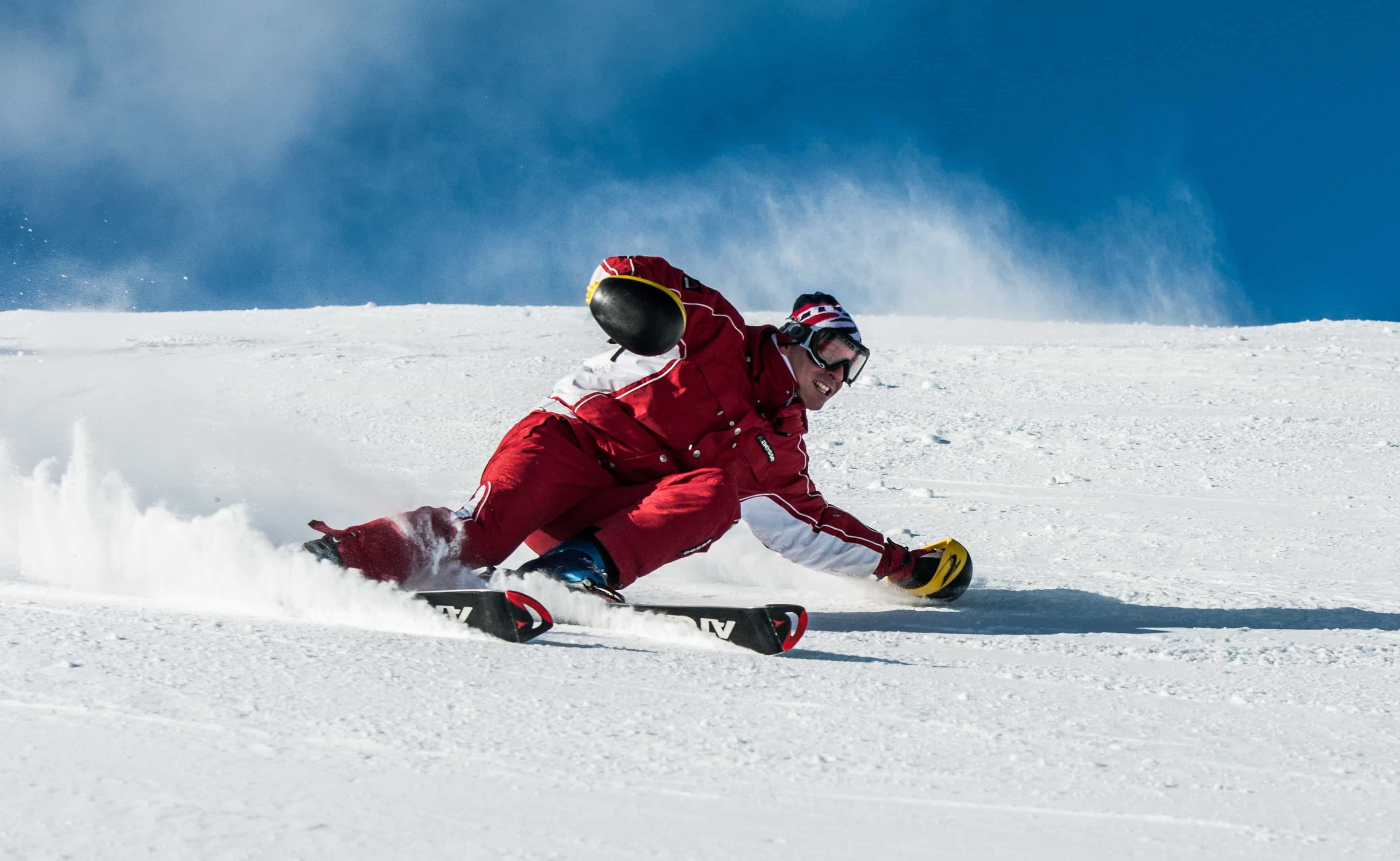 Man in red skiing down a slope