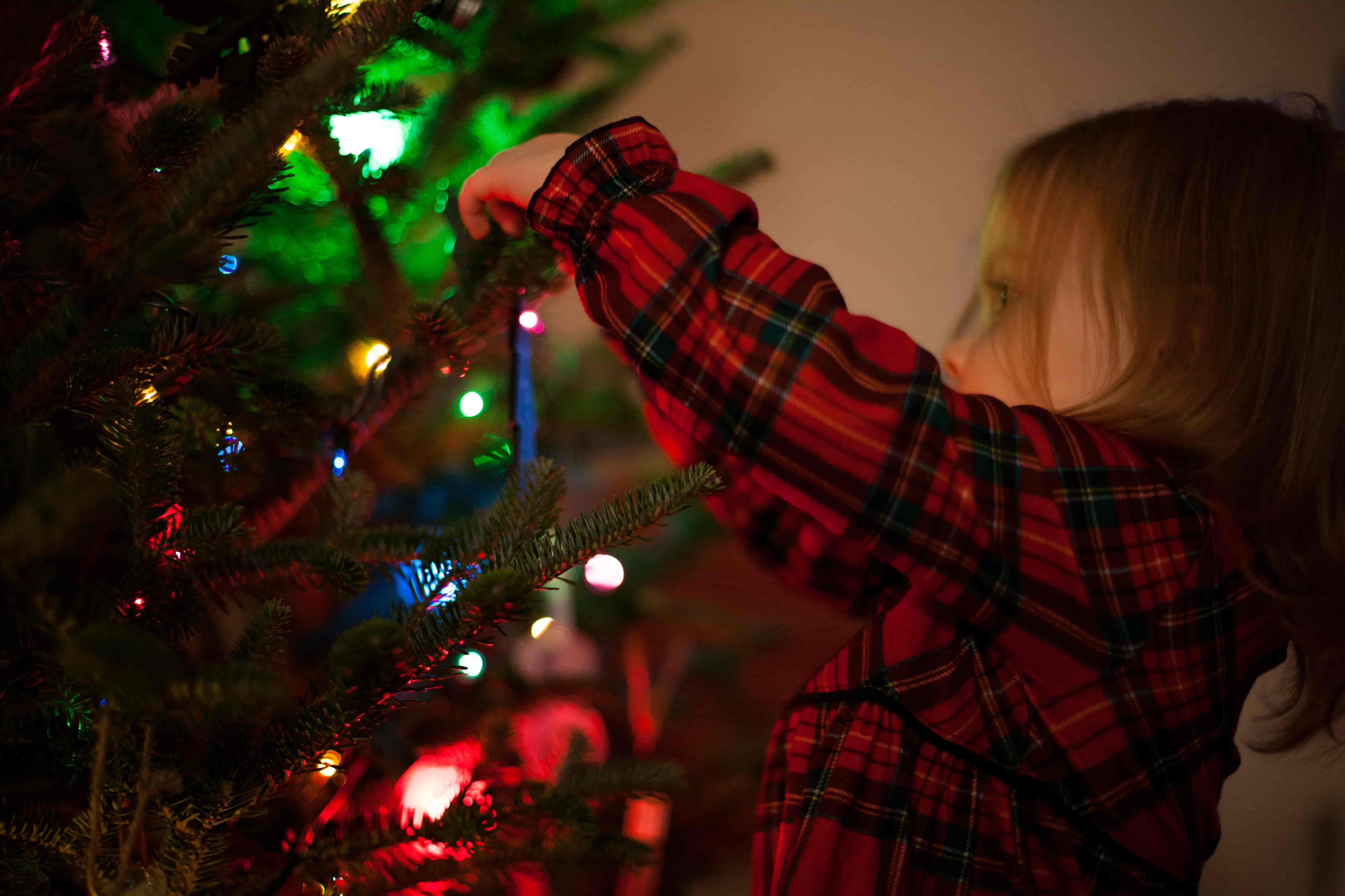 Child decorating a christmas tree