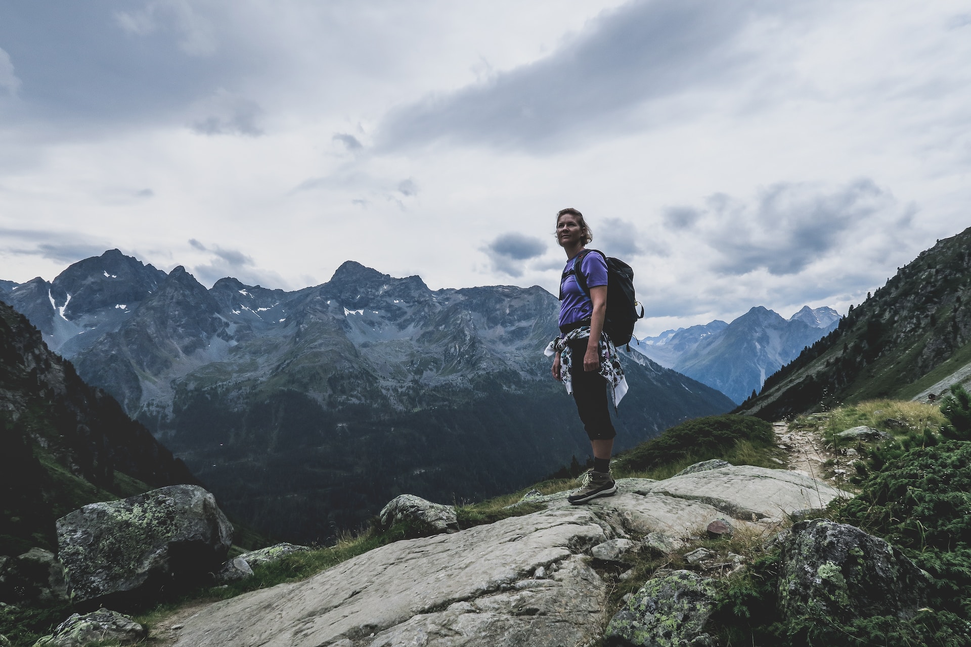 Lady in hiking gear walking up an Alps mountain